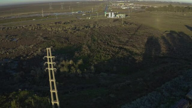 Campo con una laguna y un poste de electricidad