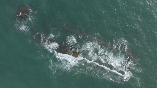 Slow motion view of parts of the dredger ship during dismantling, under the water surface. 360 degree vertical aerial view.
