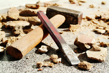 Hammer and chisel between boulders.