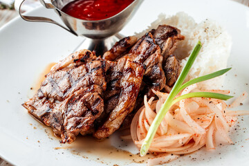 Grilled beef meat with rice and red sauce