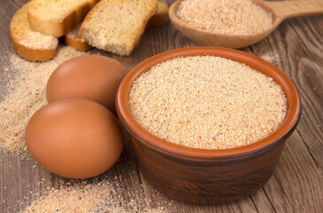 Bowl with breadcrumbs on wooden table