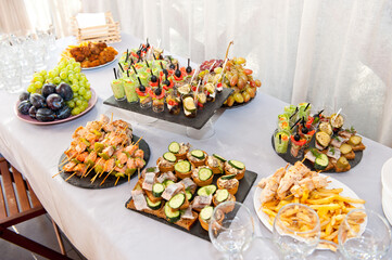 The table is served with dishes with fruits and other meat snacks for a buffet table.