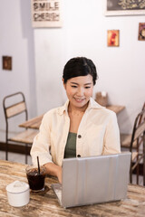 カフェでノートパソコンを使う女性