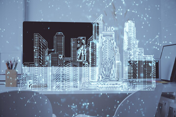 Desktop computer background in office and big town buildings hologram drawing. Double exposure. Smart city concept.