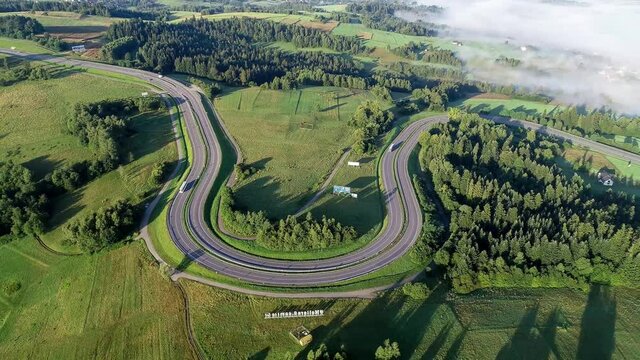 Poland. Winding switchback road from Krakow to Zakopane, called Zakopianka, near Rabka and Chabowka. Aerial video in sunrise light with morning fog. 