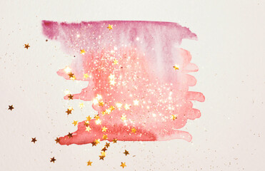 Golden glitter and glittering stars on abstract pink watercolor splash in vintage nostalgic colors on light gray background	