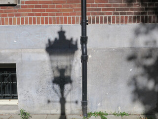 shadow of an antique lantern projected on a stone wall