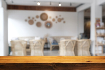 Empty wooden desk space and blurry background of cafe or Restaurant for product display montage