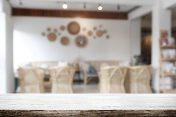 Empty wooden desk space and blurry background of cafe or Restaurant for product display montage