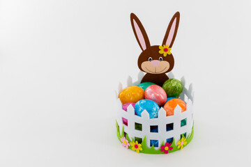 Colorful Easter eggs in a basket with an Easter bunny