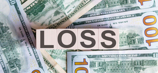 Concept words LOSS on wooden blocks on a beautiful background from dollar bills.