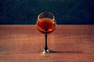 Glass with whiskey or brandy on a wooden surface, a drink for the holiday