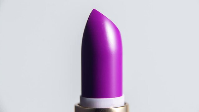 Close up video of purple lipstick rising 