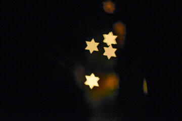 Copy space Star of David light Bokeh Effect Dark Black Background using a special camera lens filter