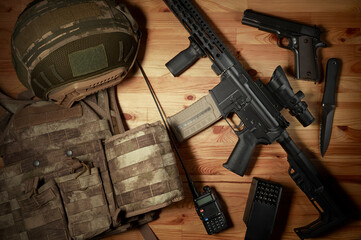 Weapons and military equipment for army, Assault rifle gun and pistol on wooden background.