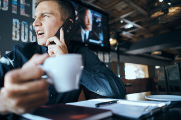 Business man with a cup of coffee in a cafe emotions work in the office stress irritability director