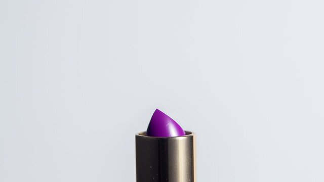 Close up video of purple lipstick rising 