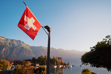 National flag of Switzerland in Swiss Alps village.