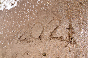 drawn numbers 2021 on the sea sand