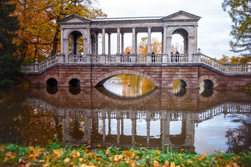 Obraz premium The bridge and autumn forest lake.