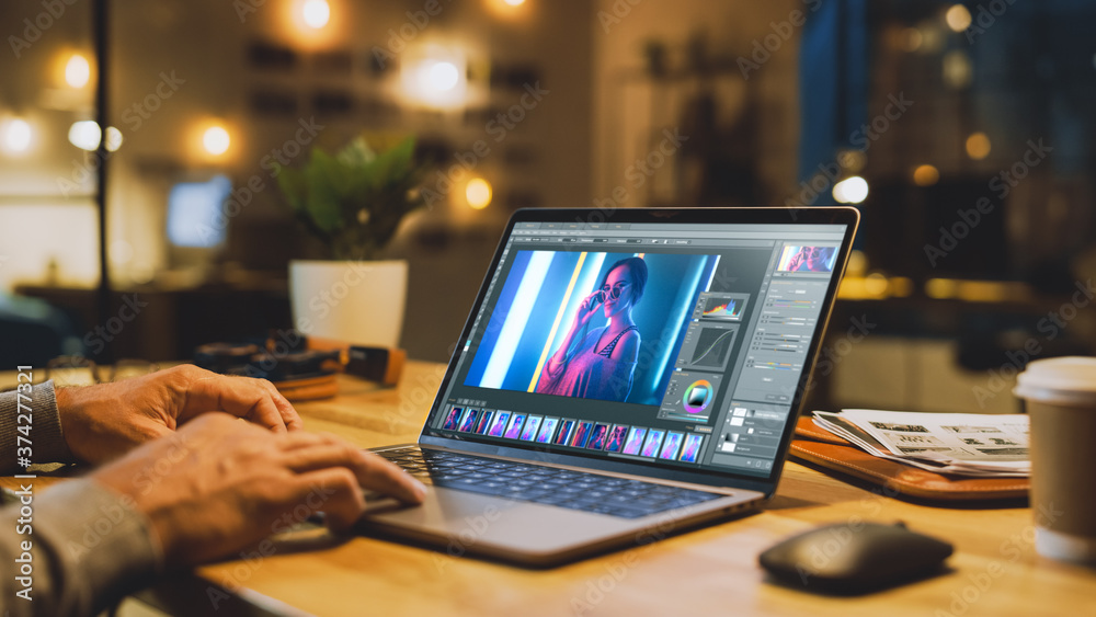 Poster shot of a male digital editor specialist works on a laptop computer in picture editing software. in 