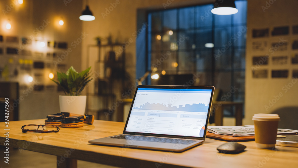 Poster laptop on the desk in the office shows company growth data with graphs, charts, software ui. in the 