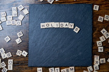holidays message written with wooden letters on slate stone