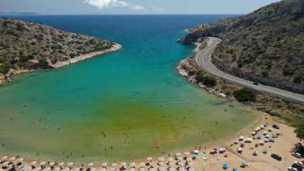 Aerial drone photo of small protected by winds cove and sandy beach of Lomvarda in Athens riviera next to Hole of Karamanlis tunnel, Vouliagmeni, Attica, Greece