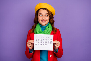 Close-up portrait of her she nice-looking attractive lovely pretty cute cheerful wavy-haired girl holding in hands paper calendar creating plan isolated on violet lilac purple pastel color background