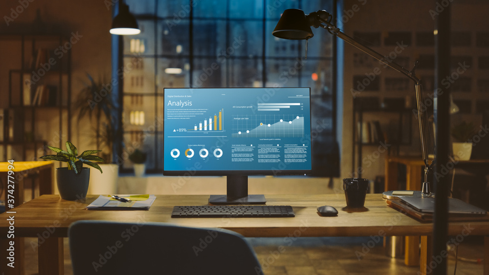 Poster Shot of a Desktop Computer with Statistics Graph, Chart and Various Data, Showing Company Growth and Success. In the Background Warm Evening Lighting and Open Space Studio with City Window View.