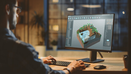 In the Evening Creative Young Video Game Developer Works on a Desktop Computer with Screen 3D...