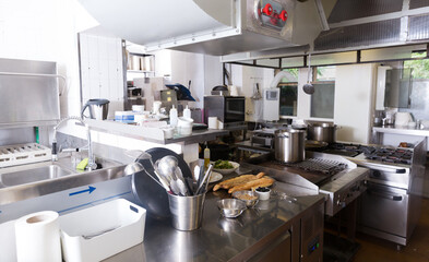 View of empty restaurant kitchen with professional equipment and products..