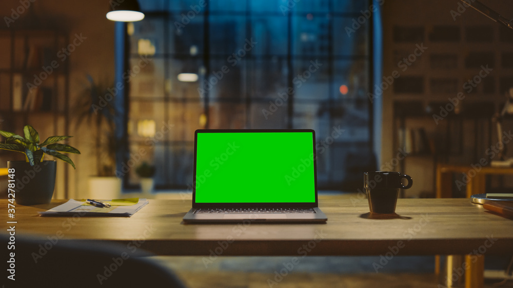 Poster mock-up green screen laptop standing on the desk in the modern creative office. in the background wa
