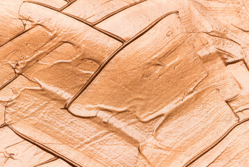 Metallic glosary brown makeup smears of creamy foundation textured background