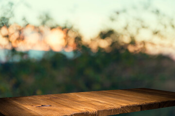 Empty wooden deck table with foliage bokeh background. Ready for product display montage.