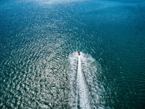 Aerial drone photo of stunt man performing extreme stunts with jet ski water craft over the Black sea at dusk