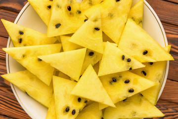 Closeup of fresh yellow watermelon slices on white plate