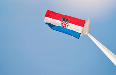 National croatian flag waving against blue sky.