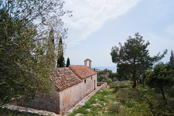 Ancient small catholic chapel made from stones with tiled roof.