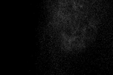 Abstract splashes of water on black background. Freeze motion of white particles. Rain, snow overlay texture.