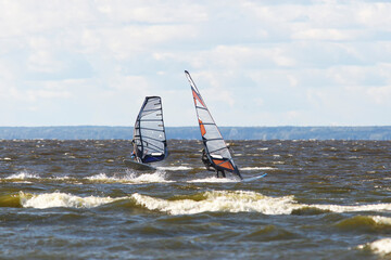 Windsurfers sportsmen on sea waves