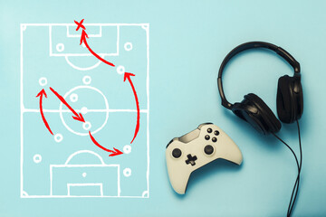 Headphones and gamepad on a blue background. Added drawing with the tactics of the game. Football. The concept of computer games, entertainment, gaming, leisure. Flat lay, top view.
