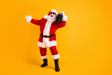 Fototapeta na wymiar Full length body size view of his he nice funny cheerful cheery white-haired Santa dj mc deejay carrying boombox dancing having fun isolated bright vivid shine vibrant yellow color background