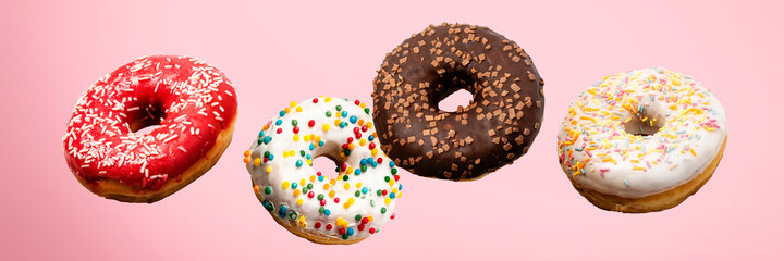 Donuts flying in the air on a pink background. Bakery, baking concept. Levitation. Banner