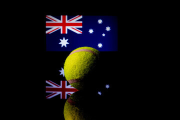 Yellow Tennis Ball on black mirror with Australian Flag in the background