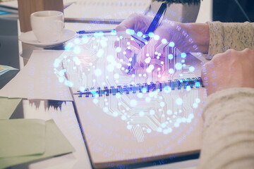 Double exposure of writing hand on background with brain hologram. Concept of learning.