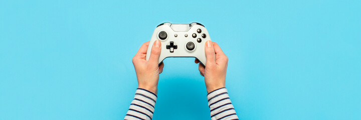 Hands holding a gamepad on a blue background. Banner. Concept games, video games