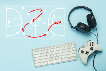 Keyboard, headphones and gamepad on a blue background. Added drawing with the tactics of the game. Basketball. The concept of computer games, entertainment, gaming, leisure. Flat lay, top view.