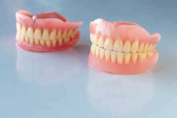 The dentures of the two elderly people were placed on a shiny white table.