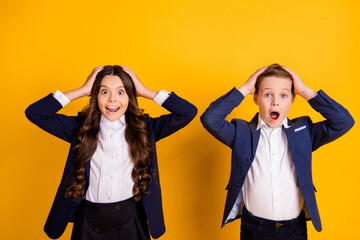 Portrait of his he her she attractive glad cheerful amazed lucky schoolkids success a-mark result news test exam reaction isolated bright vivid shine vibrant yellow color background